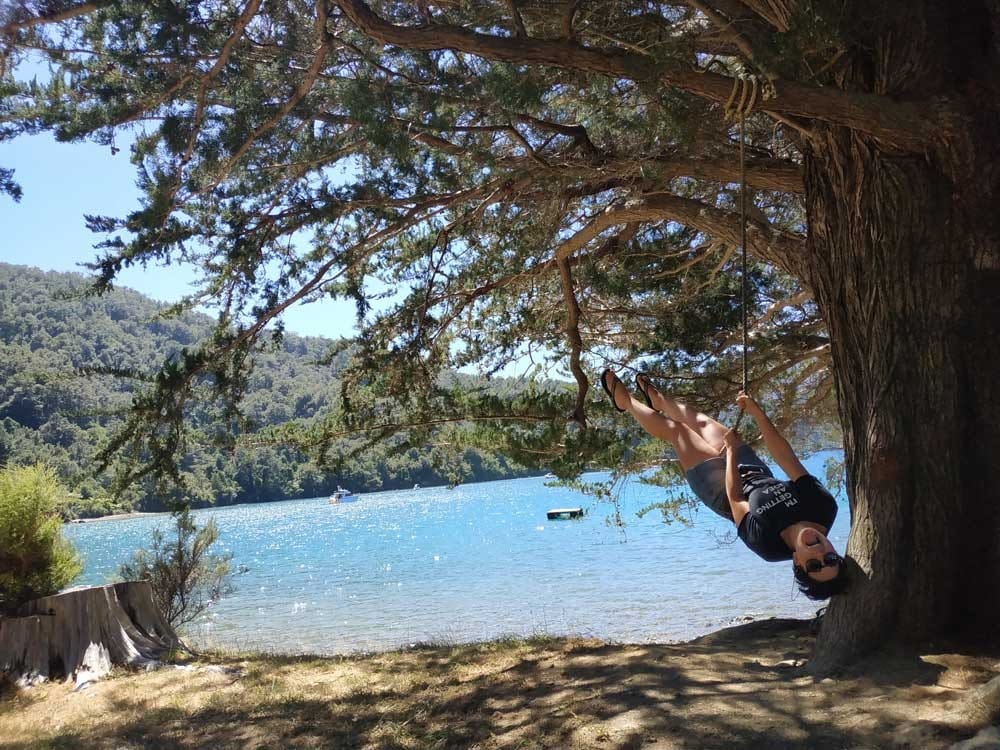 qué ver en Nueva Zelanda chica en un columpio y de fondo un lago